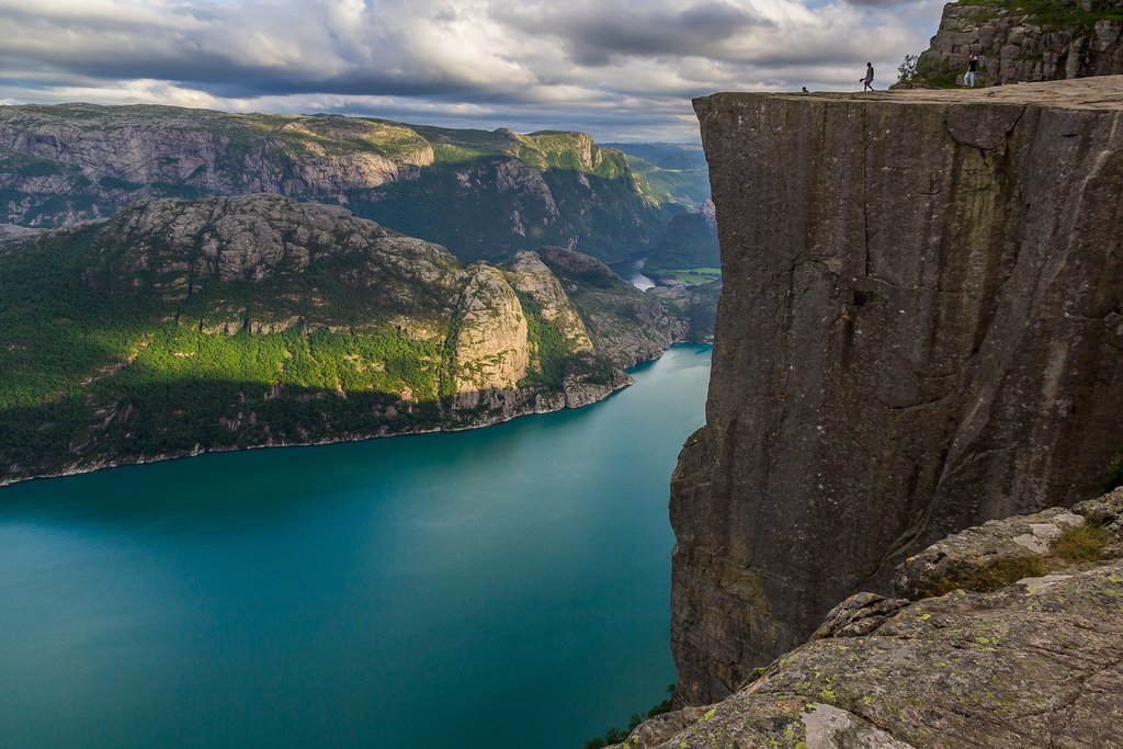 A cruise ship navigating a steep Norwegian Fjord